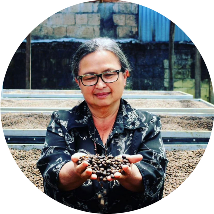 Mayra Soris, farmer in Costa Rica, holding beans drying on a drying bed on her farm