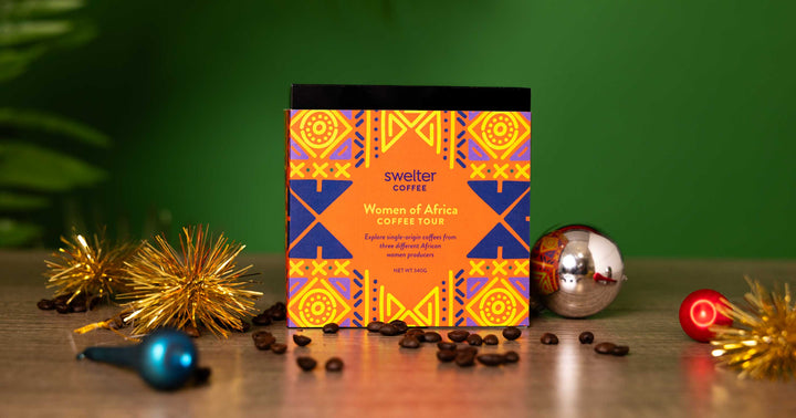 Swelter Coffee Women of Africa coffee box with decorative elements on a wooden surface.