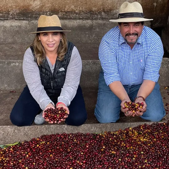 Lilly and David Rodriguez holding coffee cherries